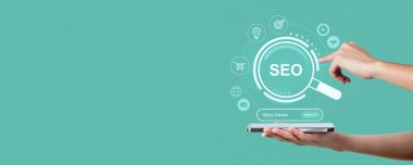 SEO hologram arayüzü, dijital pazarlama sembolleri ve yeşil arkaplanda arama çubuğu olan tablet kullanan eller. Çevrimiçi iş başarısı kavramı
