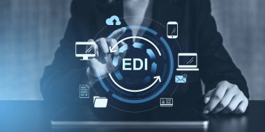 EDI dijital arayüz simgelerine sahip bir tablet kullanan business sperson, modern bir iş ortamında elektronik veri alışverişini sembolize ediyor