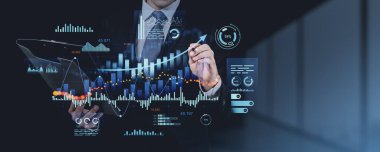 Bir ofis ortamında saydam bir dijital ekrandaki finansal verileri analiz eden işadamı, çizelgeler, grafikler ve istatistikler ile teknolojiyi temsil ediyor.