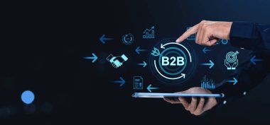 İşadamı, tabletten yansıtılan B2B simgeleriyle etkileşime girer, karanlık arka planda modern dijital tarzda, iş stratejisi kavramını temsil eder