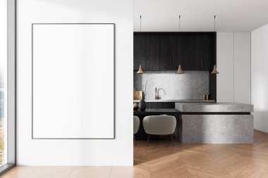 Ahşap zemin, gri taş ada ve kolye ışıkları olan modern bir mutfağın yanındaki beyaz duvarda dikey boş poster modeli. 3B Hazırlama