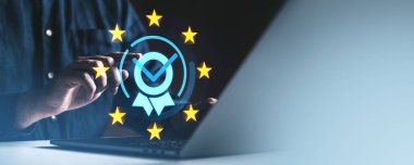 Karanlık arka planda dijital kalite kontrol simgesi ve AB yıldızlarına sahip dizüstü bilgisayar kullanan bir adam, GDPR uygunluğunu ve veri korumasını simgeliyor