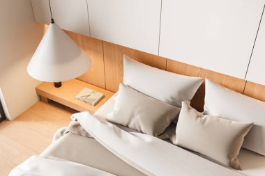 Minimalist iç yatak odası, rahat bir yatak odası, bej yastıklar, ahşap yatak başlığı, ve ahşap komodinin üzerinde beyaz bir lamba. 3B Hazırlama