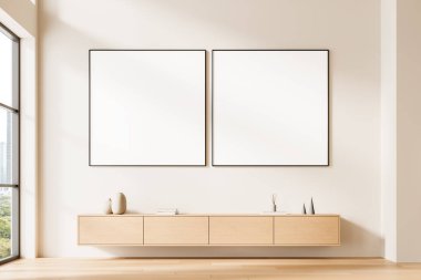 Açık ahşap dolabın üstündeki bej duvarda iki boş poster bilgisayarı, asgari modern iç mekan, gün ışığı ayarı, temiz düzen konsepti, 3 boyutlu tasarım