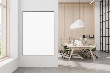 Modern ofisin temiz beyaz duvarında çerçevelenmiş boş poster modeli. Ahşap dekor, ortak masalar ve doğal ışık. 3B Hazırlama
