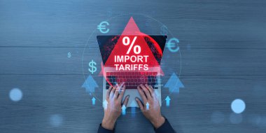 Bilgisayarda kırmızı bir sembolle ithalat tarifeleri, modern grafik unsurları, ahşap masa arkaplanı, ticaret büyümesi ve ekonomik savaş kavramları yazan eller.