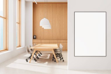 Beyaz duvarda boş bir poster parlak ofis içinde ahşap masa, sandalyeler ve kolye ışıkları, minimalist ekran konsepti. 3B Hazırlama