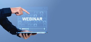 Bir el, tablet, modern grafik tarzı, mavi arkaplan, çevrimiçi e-öğrenim ve eğitim kavramı üzerinde yüzen dijital bir webinar ekrana işaret eder