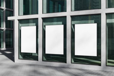 Modern bir binanın büyük cam pencerelerine asılmış üç boş dikey poster, kentsel arka planda gerçekçi 3D görüntüleme, temiz model konsepti
