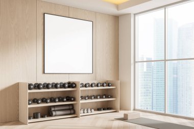 Modern jimnastik salonunda boş poster modeli, hafif ahşap duvarlar, raflarda dambıllar, yoga minderi ve bloklar, büyük pencerelerden şehir manzarası, 3 boyutlu görüntüleme.