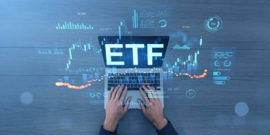 Eller dizüstü bilgisayarda ETF metni ve dijital stok grafikleri, hologramlar, fütüristik stil, ahşap yüzeye yerleştirilmiş, teknoloji yatırımı kavramı