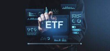Tablet, fütüristik grafik tarzı, koyu arkaplan, modern yatırım teknolojisi kavramı üzerindeki ETF dijital arayüzü ile etkileşimde olan kişi