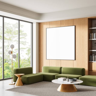 Modern oturma odası yeşil modüler kanepe, açık tahta duvar, boş beyaz çerçeve, yumuşak halıda altın mobilyalar, sıcak gün ışığı. 3B Hazırlama