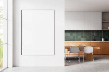 Modern çağın beyaz duvarında büyük boş bir poster çerçevesi parlak mutfak, ahşap masa, yeşil fayans kaplama ve pencere manzaralı. 3B Hazırlama