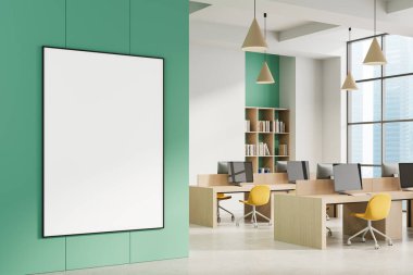 Ahşap masaları, sarı sandalyeleri ve büyük pencereleri olan modern ofis içinde yeşil duvarda büyük boş bir poster çerçevesi. 3B Hazırlama
