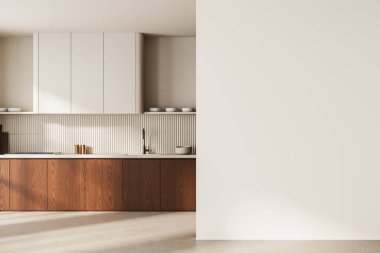 Minimalist mutfak iç dekorasyonu, ahşap alt dolaplar, beyaz üst dolaplar, ve açık arkaplanda poster modelleri için boş duvar. 3B Hazırlama