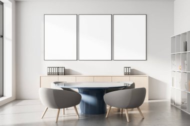 Yuvarlak masa, gri koltuklar ve parlak duvarda boş dikey posterler, 3D tasarım, minimalist iç tasarım.