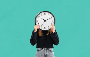 Yüzünün önünde yuvarlak bir duvar saati tutan bir kadın, zaman yönetimi ve kimlik kavramını temsil eden sağlam bir deniz mavisi arkaplanına karşı duruyor.