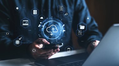 Dijital bulut hesaplama simgelerine sahip akıllı telefon ve dizüstü bilgisayar kullanan kişi, geleceksel arayüz biçimi, koyu bulanık arkaplan, veri kavramı ve ağ yönetimi