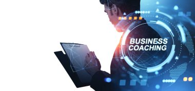 Panoya dijital HUD kaplamalı, fütüristik tarzda, beyaz ve mavi teknolojili bir iş adamı yazıyor. İş koçluğu ve yenilik kavramı