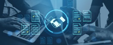 Yüzen dijital belge simgeleri ve el sıkışma grafikleriyle dizüstü bilgisayarlarda yazı yazan iki kişi, mavi arkaplan, online sözleşme kavramı ve veri anlaşması