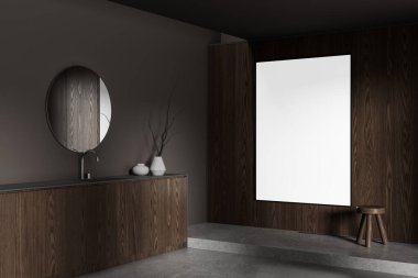 Ahşap paneller, dairesel ayna ve temiz, karanlık bir arka planda boş dikey poster modeliyle modern minimalist iç mekan. 3B Hazırlama