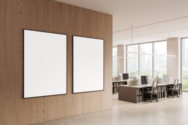 Parlak ofis içi aydınlık ahşap duvara asılı iki boş poster, temiz modern tarz, beton zemin ve büyük pencereler. Tasarım modeli kavramı. 3B Hazırlama