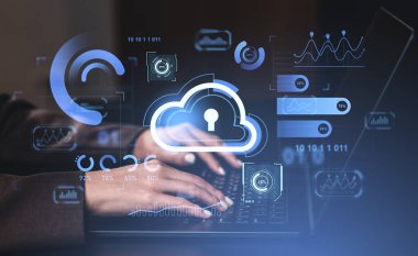 Hands typing on laptop keyboard with glowing cloud lock icon and analytic data graphics on dark gradient background. Concept of cybersecurity and cloud