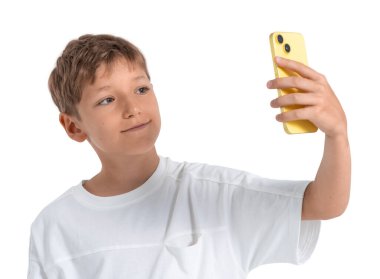 Young boy holding yellow phone taking selfie, casual style, isolated on white background. Concept of childhood, technology, communication, modern life