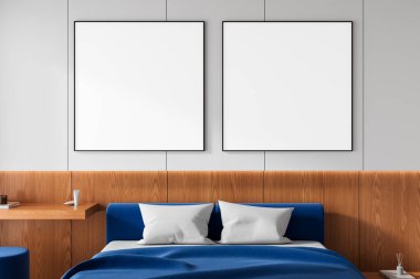 Contemporary bedroom with two white posters on wall above blue bed with wood paneling background, perfect for interior design mockup template. 3D Rendering