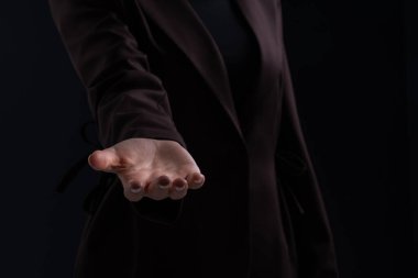 Close-up of a woman open hand reaching forward, realistic style, dark background. Concept of support, connection, offering, trust, unity