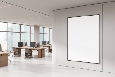 Empty vertical poster mockup in modern open space office with wooden desks, computers, and panoramic windows. 3D Rendering