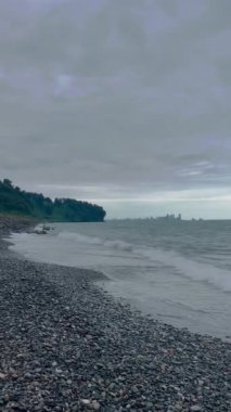 Deniz kıyısında dalgalar ve kasvetli gri bir gökyüzü