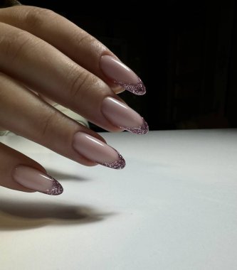 Light manicure with glitter on long nails clipart