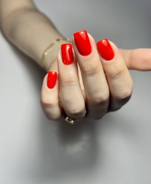 Kare parmaklarda kırmızı manikür.