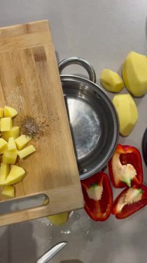 Doğranmış patatesler bir tencereye dökülüyor.