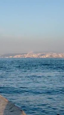 Güzel mavi dalgalı deniz ve ufuktaki şehir