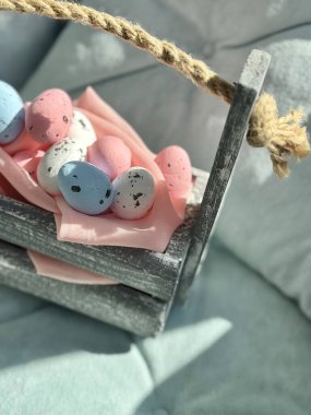 Pembe kumaşlı küçük Paskalya yumurtalarının olduğu tahta sepet.