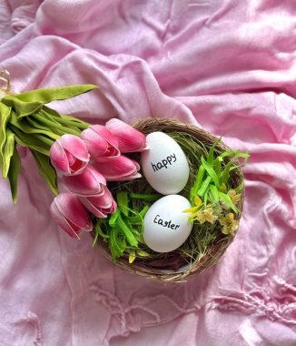 Güzel bir buket pembe lale ve paskalya yumurtalı hasır yuva.