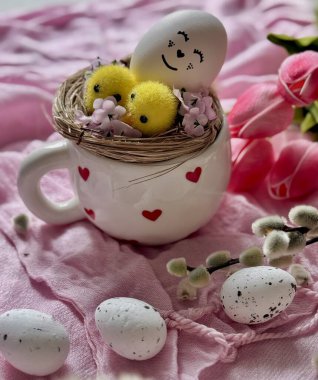 Dekoratif yuvalı seramik bardak ve sevimli sarı piliçler.