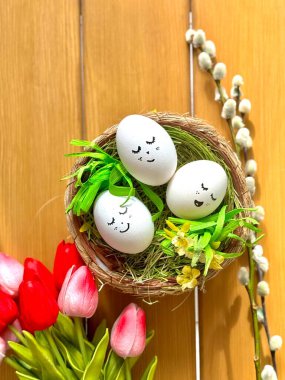 Sepette süslü yumurtalar, pembe laleler ve söğüt dalı.