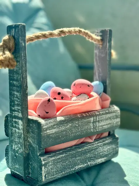 Renkli Paskalya yumurtalarıyla dolu küçük tahta bir sepet.