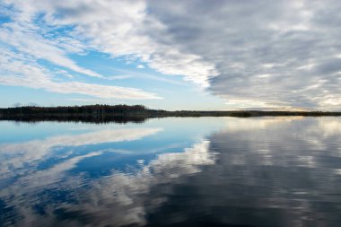 dramatik, zıt gökyüzü gölün yüzeyindeki yansımalarla ufuktaki karanlık ağaç siluetleri, sonbahar