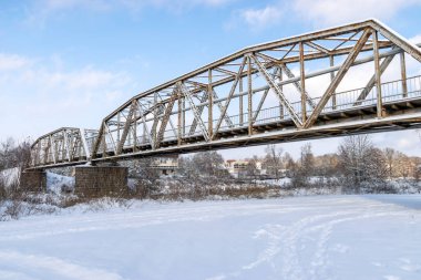 Demirden köprüsü olan güneşli kış manzarası, Valmiera, Letonya