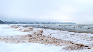 Deniz kıyısından kış manzarası, deniz kıyısında uzanan buz parçaları, kum tepelerinde kum ve buz dokusu, Baltık Denizi, kışın Letonya