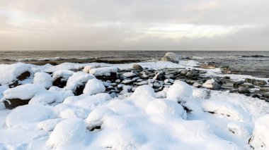 Deniz kıyısındaki kayalarda farklı buz oluşumları, buz dokusu, rüzgar, su ve buz birlikte çalışıyor, kışın deniz kenarında.