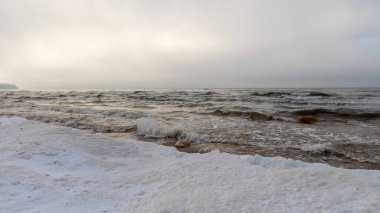 Deniz kıyısından kış manzarası, deniz kıyısında uzanan buz parçaları, kum tepelerinde kum ve buz dokusu, Baltık Denizi, kışın Letonya