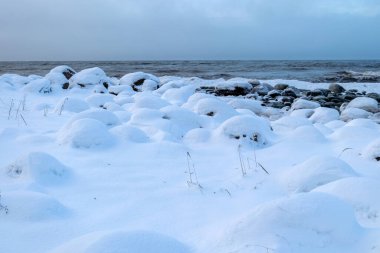 Deniz kıyısından kış manzarası, deniz kıyısında uzanan buz parçaları, kum tepelerinde kum ve buz dokusu, Baltık Denizi, kışın Letonya