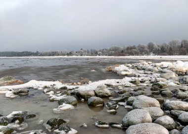 Deniz kıyısındaki kayalarda farklı buz oluşumları, buz dokusu, rüzgar, su ve buz birlikte çalışıyor, kışın deniz kenarında.