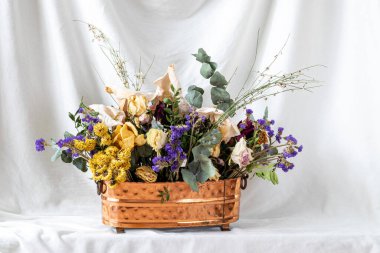 composition of dry flowers in a vase, white fabric background, still life with dry flowers
